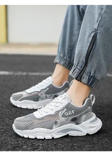 Vista laterale dettagliata delle scarpe da corsa in mesh traspirante grigio e bianco