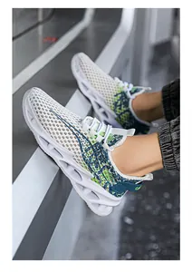 Primer plano de zapatillas de punto para hombre con malla blanca y detalles verdes