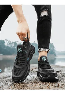 Close-up detail of black breathable mesh men's running shoes with cyan logo for summer