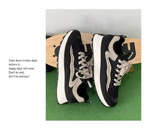 Λεπτομερής πλάγια όψη από μαύρα και μπεζ sneakers τρεξίματος πάνω σε skateboard