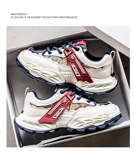 Λεπτομερής προβολή μπεζ ανδρικών chunky sneakers με κόκκινες πινελιές σε κουτί