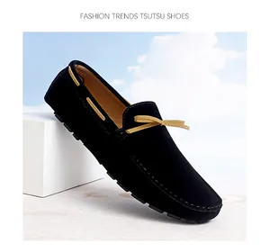 Black suede driving loafer with yellow bow detail shown at a dynamic side angle.