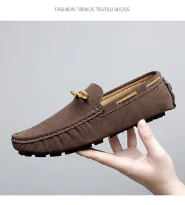 Macro detail of brown suede loafers featuring yellow laces and contrast stitching