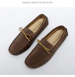 Top-down view of men's brown suede loafers with decorative bow and visible stitching