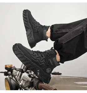 Detail shot of black mid-top outdoor work boots on a vintage motorcycle.