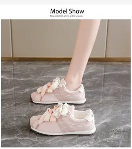 Side view of pink suede sneakers for women worn by a model on a luxury marble floor.