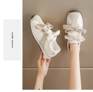Detailed view of women's off-white suede casual sneakers with stylish thick laces