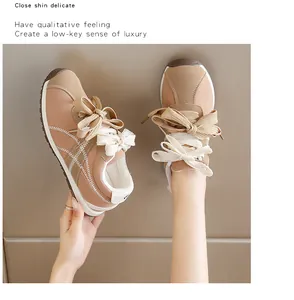 Close-up view of suede sports sneakers featuring unique double bow laces in khaki and white