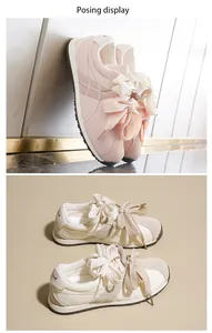 Close-up detail of women's suede sneakers with elegant oversized ribbon bow laces