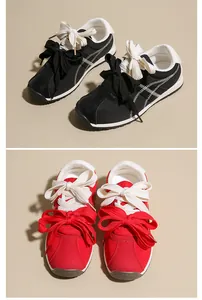 Detailed view of women's suede sneakers in black and red featuring stylish double bow laces.