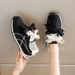 Women's black suede casual sneakers with white tiger stripe stitching and double bows