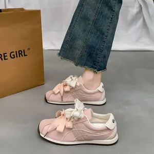 Stylish pink suede casual sneakers for women featuring elegant oversized bow laces