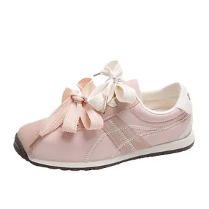Light pink women's suede sneakers with large decorative bow and contrast stitching