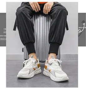 Dettaglio di sneakers basse traspiranti nei colori bianco e giallo.
