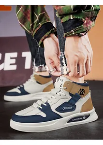 Gros plan de chaussures de skate montantes pour hommes en bleu marine, beige et blanc.