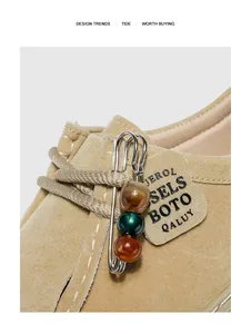 Gros plan d'une épingle avec des perles colorées sur un mocassin en microfibre kaki
