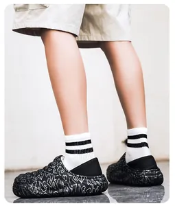 Detailed view of men's winter warm waterproof cotton slippers with white graffiti print.