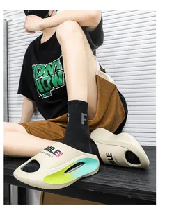 Nahaufnahme der beigen EVA-Sandalen mit Neon-Farbverlauf und der Aufschrift 'SMILE'