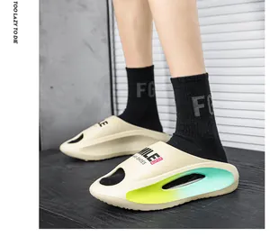 Detailansicht von cremefarbenen EVA-Slides mit neongelber Sohle und schwarzen Socken