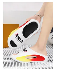 Detailaufnahme der weißen EVA-Slipper mit rot-gelbem Farbverlauf und SMILE-Schriftzug