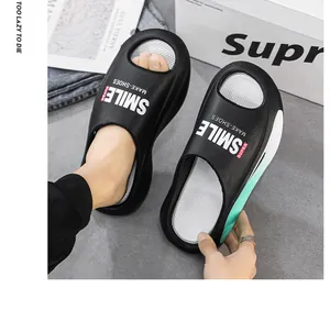 Detail von schwarzen EVA-Slippern mit "SMILE"-Aufdruck und weicher Sohle.
