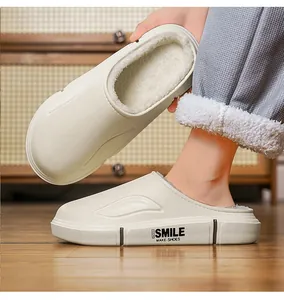 Détail de mules d'hiver blanches doublées polaire avec logo 'SMILE' sur la semelle