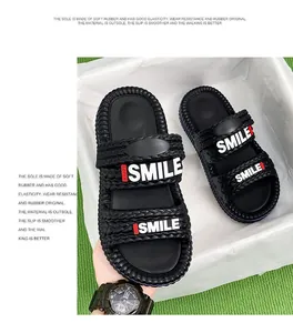 Vista dettagliata dei sandali da uomo neri con cinturini intrecciati e stampa SMILE