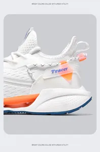 Side detail of white Flyknit running shoes featuring blade sole and vibrant orange accents