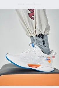 Close-up of white fly-knit sports shoe with stylish orange and blue blade sole details.
