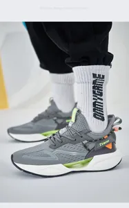 Detail of gray fly-knit men's sneakers with neon green accents and white sole