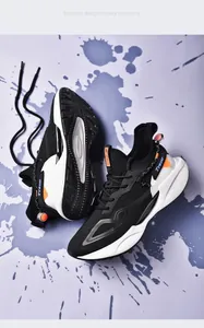 Close-up of men's black and white running shoes with blade sole and orange details