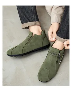 Gros plan de mocassins en daim vert olive sur modèle avec détail de fermeture éclair