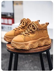 Detailed view of tan chunky platform bread shoes with thick rope laces on a stool