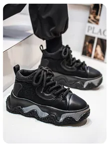 Side detail of black thick-soled chunky sneakers featuring wavy textured midsoles