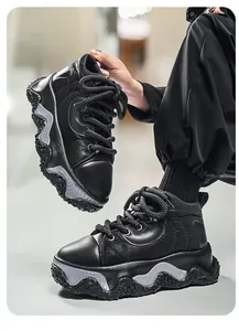 Detailed view of black chunky sole men's sneakers with unique wavy platform design