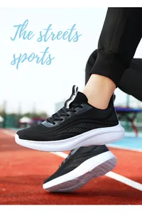 Primo piano di scarpe sportive leggere in mesh nero su una pista da corsa pro