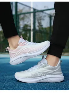 Vista laterale di scarpe da ginnastica in mesh da donna su pista blu