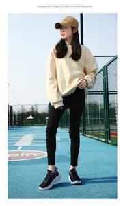 Vista a figura intera di una donna con scarpe sportive nere e viola su campo blu