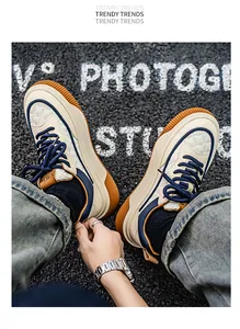 Λεπτομέρεια δερμάτινων sneakers με χοντρή σόλα και μπλε κορδόνια για καθημερινή χρήση.