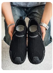 Primer plano de mocasines negros transpirables para hombre con malla y detalle de logo