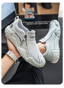 Detalle de mocasines de malla gris transpirable con diseño de cremallera en el lateral.