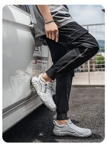 Vista lateral detallada de zapatos de lona blanca transpirable para hombre en un modelo real