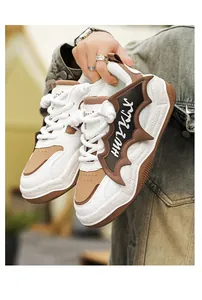 Close-up of white and brown chunky sneakers with unique bat-wing design and thick sole