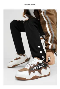 Macro detail shot of white and brown thick-sole sneakers on a male model for street style.