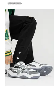 Close-up view of white and grey chunky sneakers with unique bat-wing design and lettering