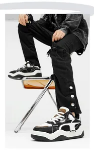 Close-up shot of stylish chunky black and white sneakers with thick soles on a model sitting