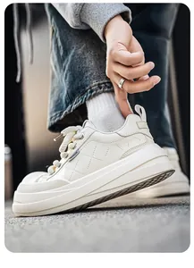 Macro view of white leather platform sneakers featuring unique cross-stitch texture