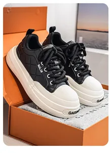 Close-up detail of luxury black and white platform sneakers placed in an orange shoebox