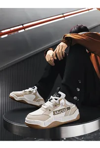 Close-up view of stylish chunky beige and white sneakers with thick soles and rope laces.