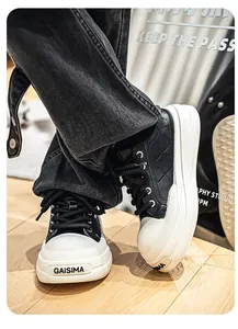 Close-up of men's black leather sneakers with thick white soles and diamond stitching